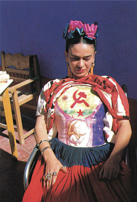 Frida Kahlo sitting on her wheelchair, lifting her clothes to show a plaster medical corset wrapped around her ribs and spine, with a bright red hammer and sickle painted over her heart.