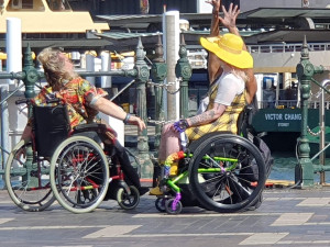 Robin, Sarah and Rodney, three wheelchair users dancing in Circular Quay.