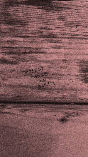 The words 'safest table on earth' are etched into a timber table