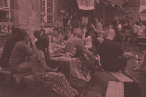 A group of people sitting and talkign around a bench